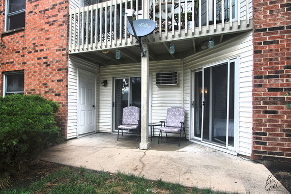 Front view of a building with a patio and balcony.