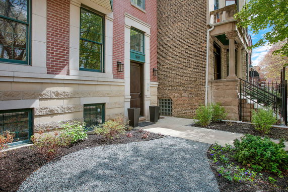 Front view of a brick multi-story building with a landscaped entrance.