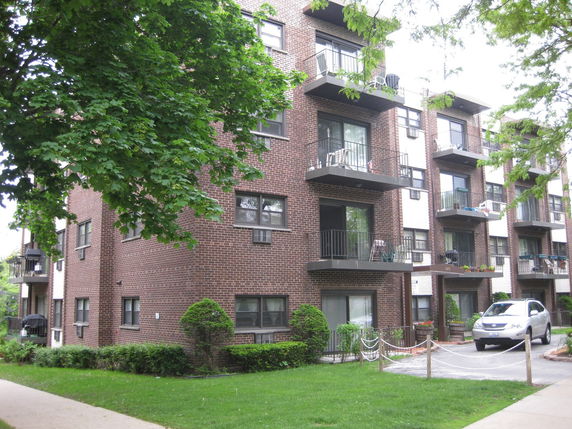 Front view of a multi-story apartment building with balconies.