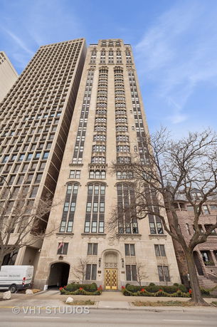 Front view of a tall multi-story building with numerous windows and decorative architectural elements.