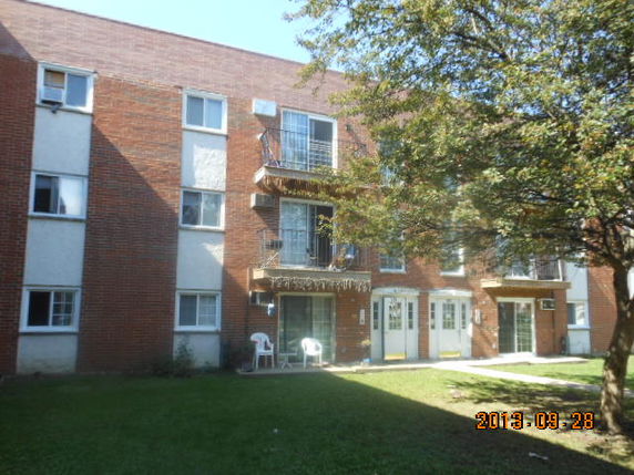 Front view of a multi-story brick apartment building.