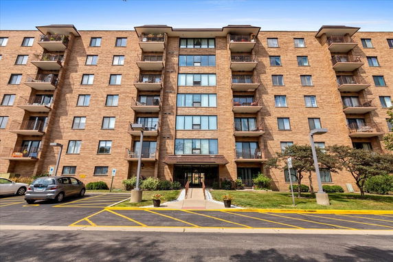 Front view of a multi-story apartment building with balconies.