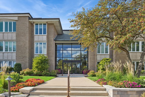 Front view of a building with large glass entrance and brick exterior.