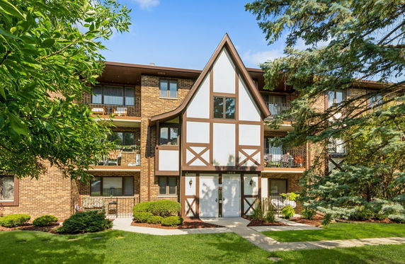 Front view of a multi-story building with Tudor-style accents and balconies.