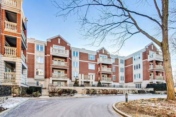 Front view of a multi-story residential building with a brick exterior and balconies.