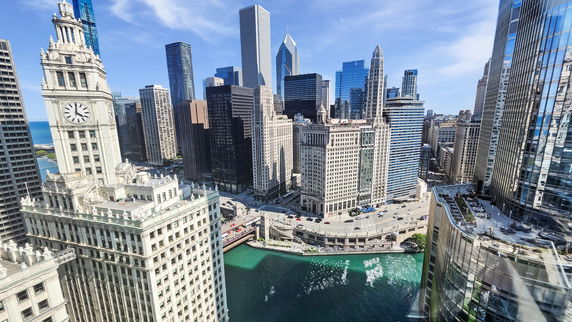 Panoramic view of a cityscape with tall skyscrapers and a river winding through the buildings.
