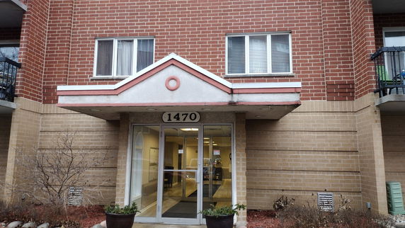 Front view of a building entrance with brick exterior and glass doors.
