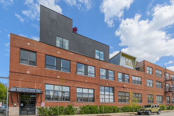 Front view of a multi-story industrial-style brick building.