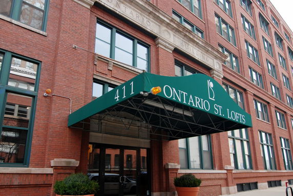 Front view of a multi-story brick building with a green canopy over the entrance.