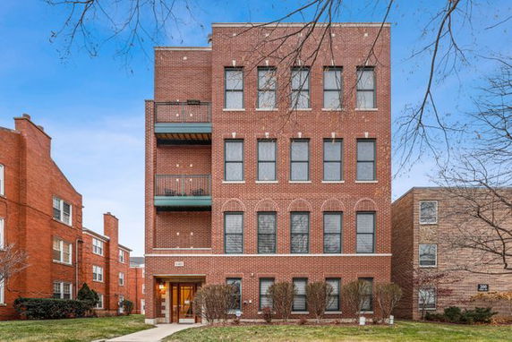 Front view of a multi-story brick building with balconies.