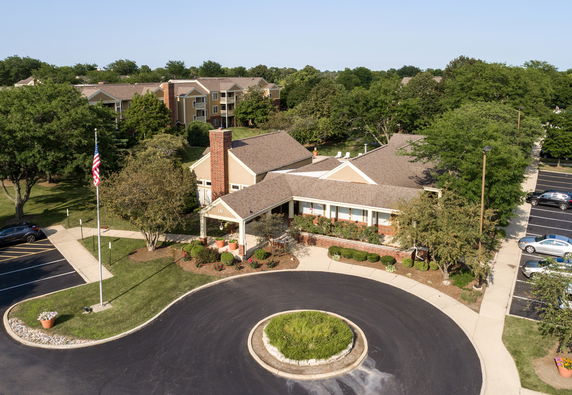Front view of a single-story building with a circular driveway and landscaped entrance.
