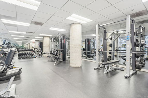 Interior view of a gym with fitness equipment and mirrors.