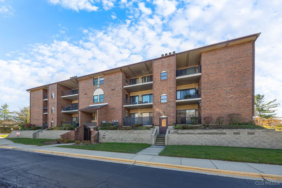 Front view of a multi-story brick apartment building.