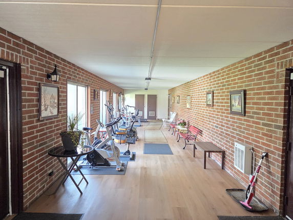 Interior view of a hallway with exercise equipment and seating.
