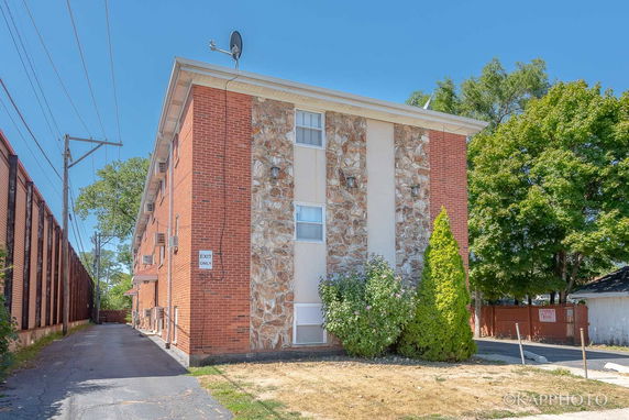 Side view of a three-story brick building with stone accents.