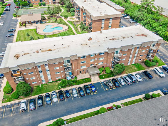 Front view of a multi-story apartment building with parking area.