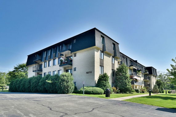 Front view of a multi-story apartment building with balconies.