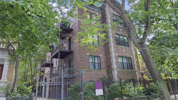 Front view of a multi-story brick building with balconies.