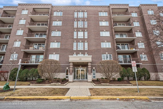 Front view of a multi-story apartment building with balconies.