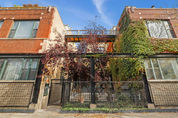 Front view of a residential building with ivy-covered walls and a connecting walkway.