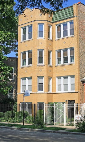 Front view of a multi-story brick building with multiple windows.