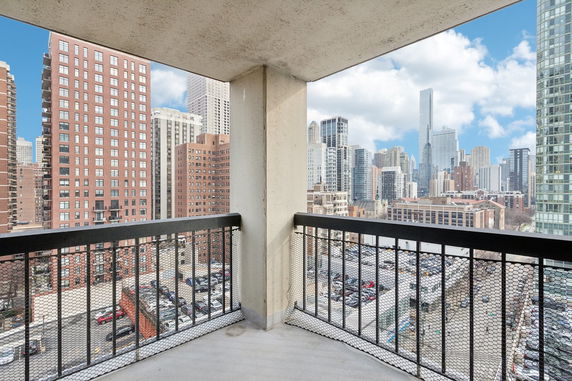 View from a balcony overlooking a cityscape with tall buildings and skyscrapers.