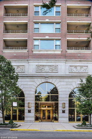 Front view of a multi-story building with large arched windows and balconies.