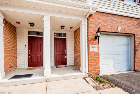 Front view of a house with two red doors and attached garage.