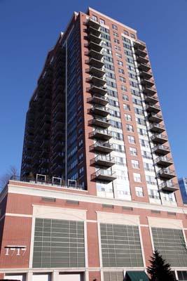 Front view of a tall residential building with multiple balconies.