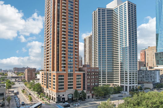 Street view of tall modern buildings with multiple stories and large windows.