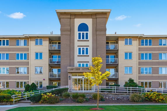 Front view of a multi-story apartment building with balconies.