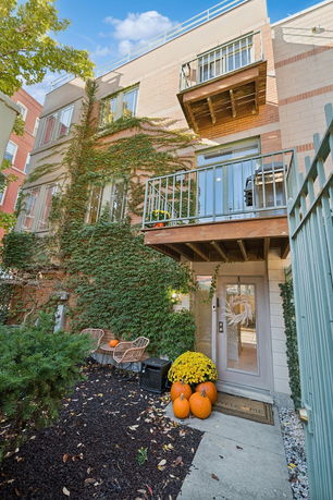 Front view of a multi-story building with ivy-covered walls and small balconies.