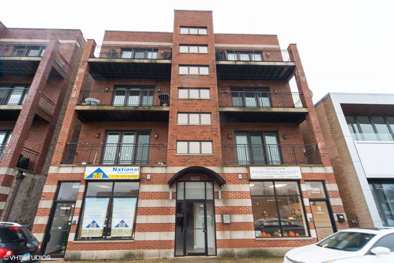 Front view of a multi-story brick building with balconies.