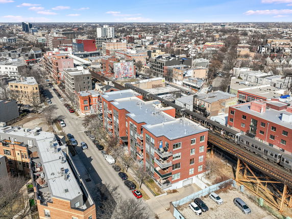 Wide aerial view of a cityscape with multiple buildings and streets.
