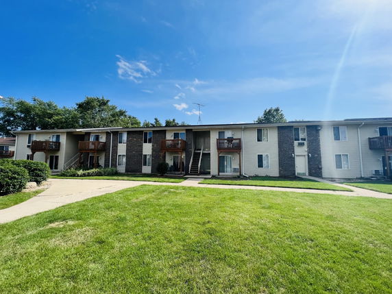 Front view of a two-story apartment building with brick and siding exterior.