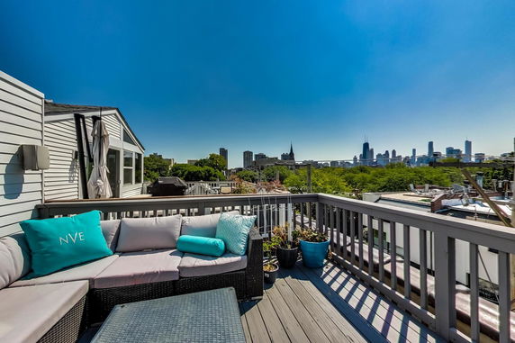 Rooftop deck with seating area overlooking city skyline.