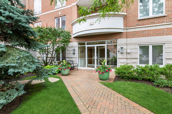 Front view of a building entrance with brick exterior and glass doors.