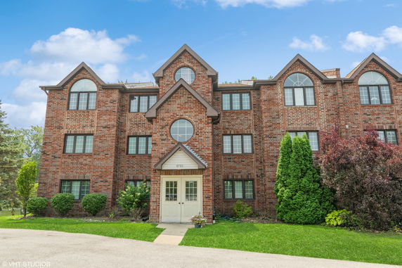 Front view of a multi-story brick building with large windows and a central entrance.