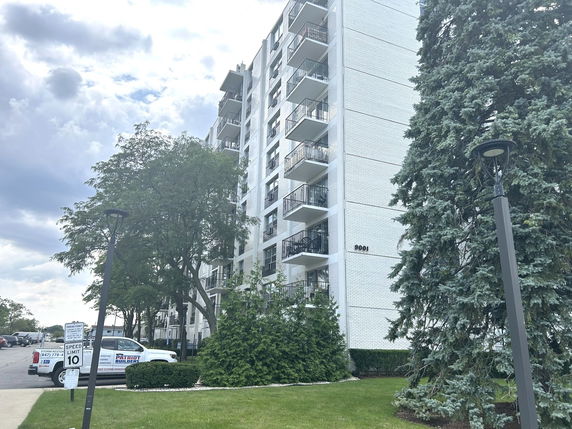 Front view of a multi-story residential building with balconies.