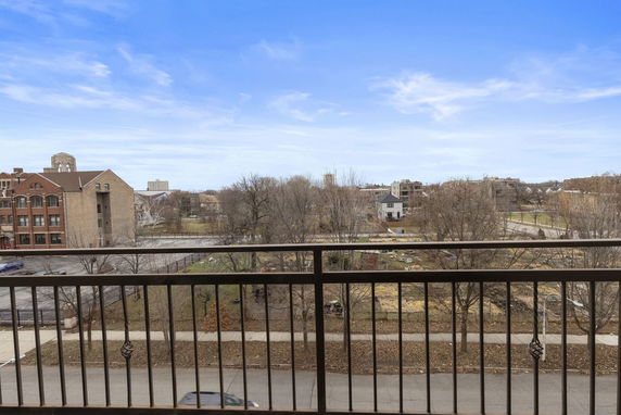 Panoramic view from a balcony overlooking a street and buildings.