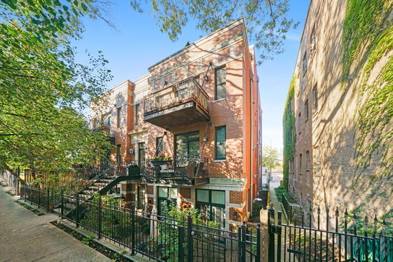 Front view of a multi-story brick building with balconies.