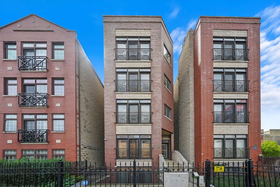 Front view of a multi-story brick building with balconies.