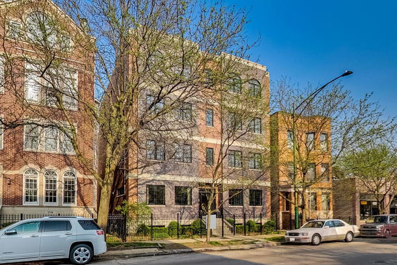 Front view of a multi-story residential building with brick facade.