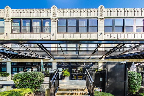 Front view of a two-story building with decorative facade and entrance canopy.