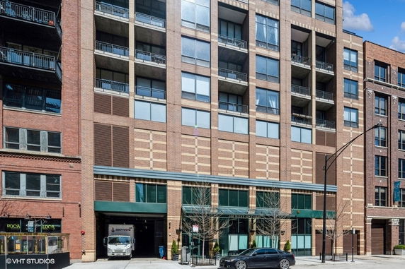 Front view of a multi-story building with balconies and a brick facade.