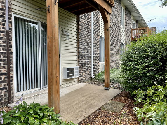 Rear view of a building with sliding glass doors and brick exterior.