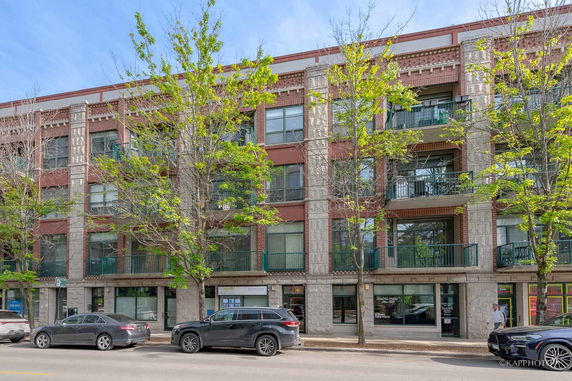 Front view of a multi-story building with balconies and large windows.