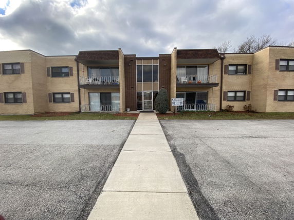 Front view of a two-story apartment building with balconies.