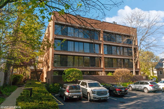Front view of a multi-story brick building with large windows.
