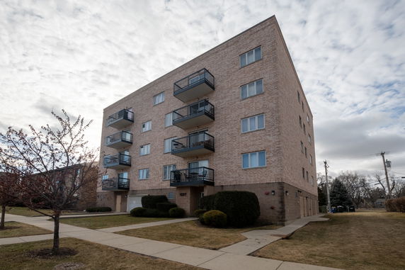 Front view of a multi-story apartment building with balconies.